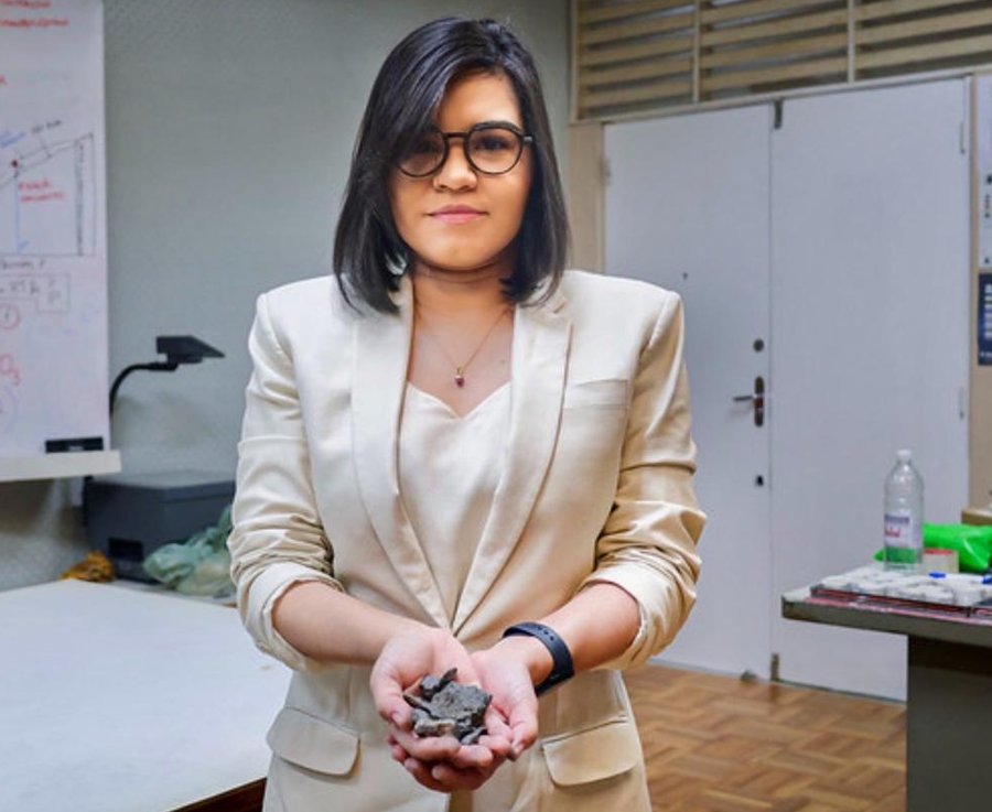 Pesquisadora em laboratório segurando fragmentos de grafita natural nas mãos
